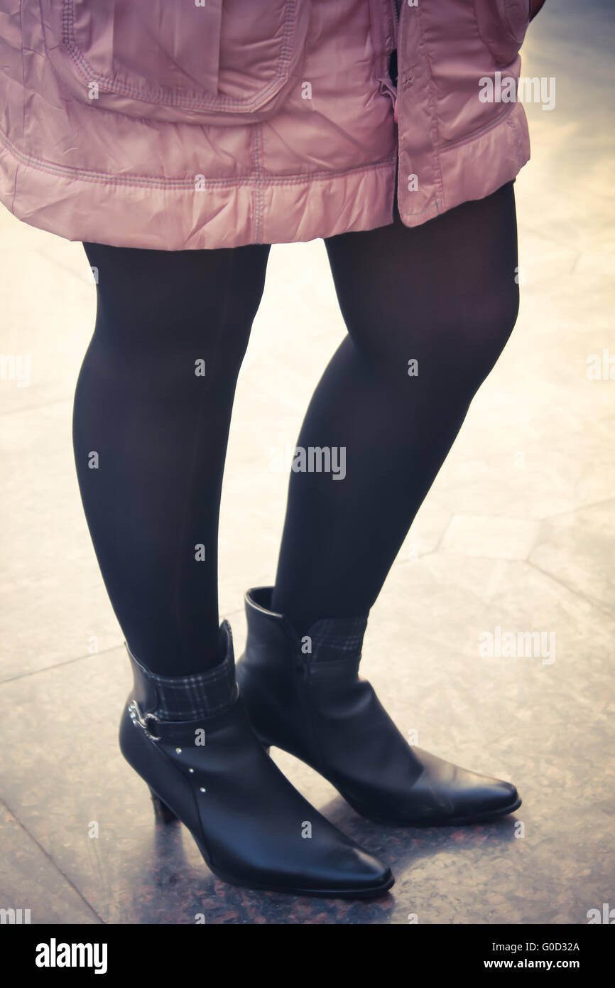 Ragazza con stivale nero e calza indossando giacca rosa - uno stile rétro Foto Stock