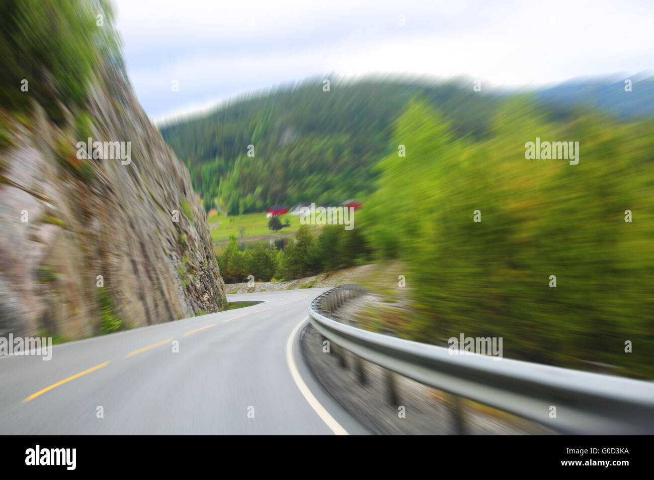 Vista sulla strada di montagna, le rocce e la foresta a brutta giornata estiva Foto Stock