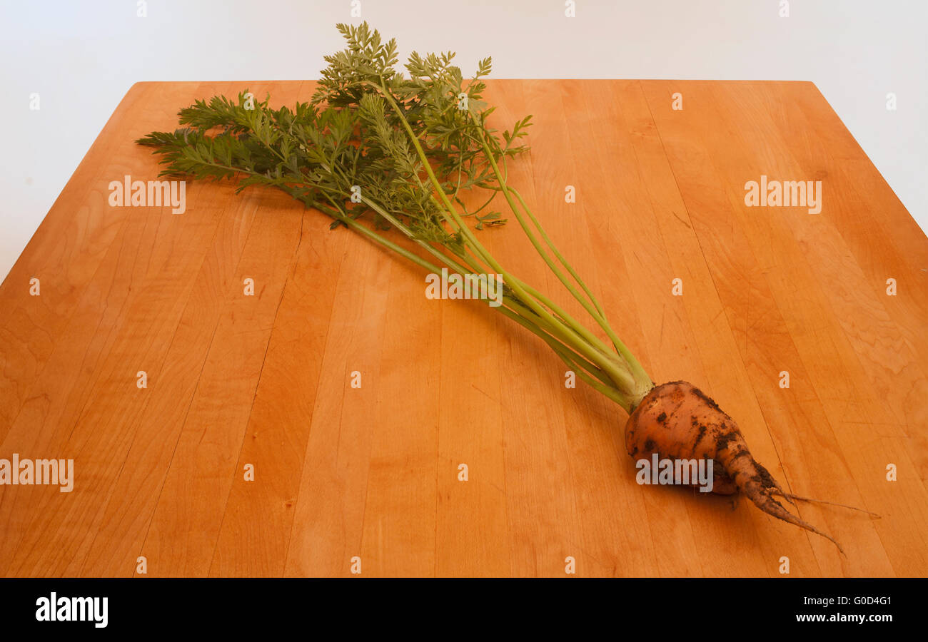 La carota su Butcher superficie del blocco Foto Stock