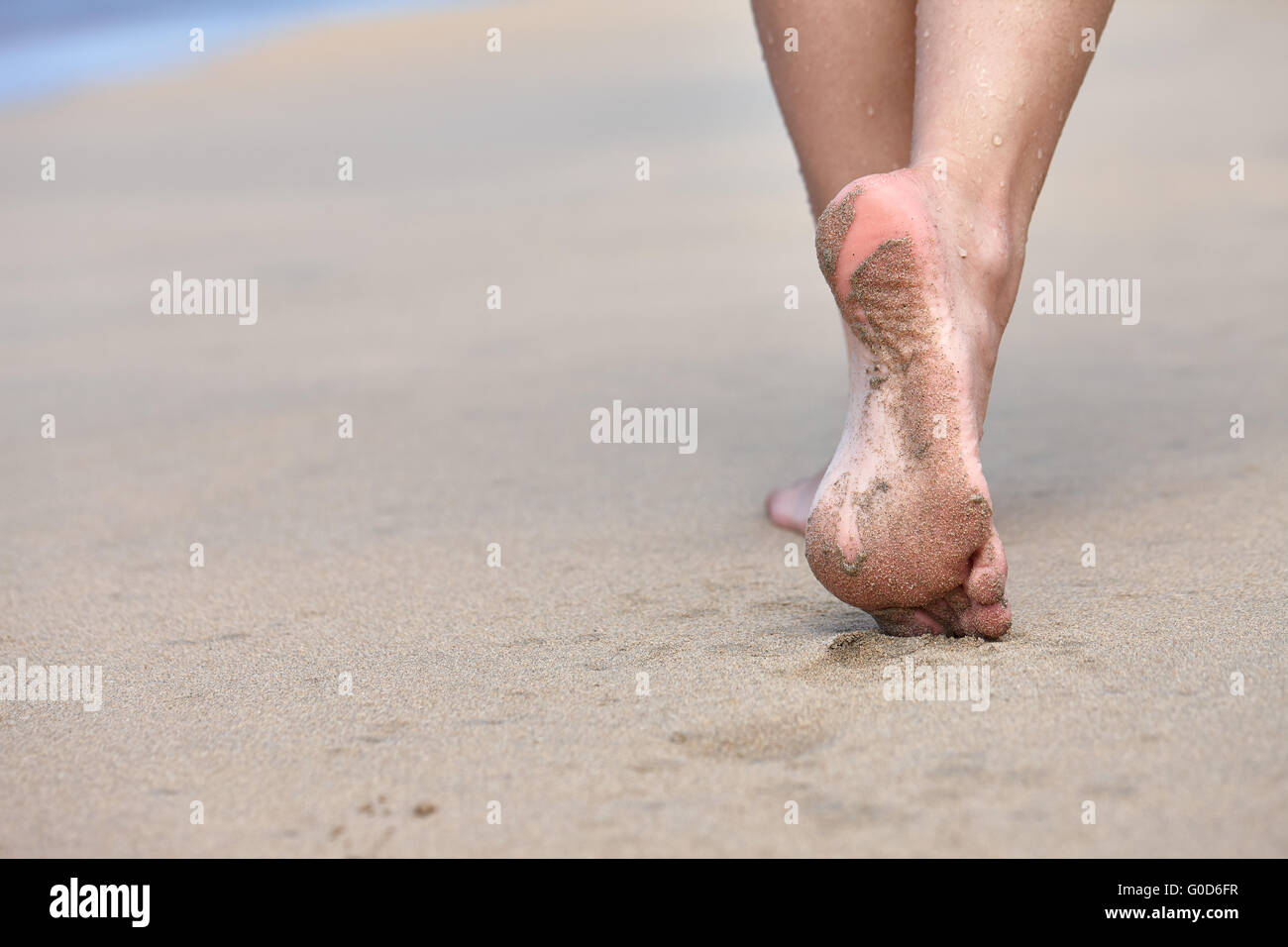 Donna che cammina su una spiaggia Foto Stock