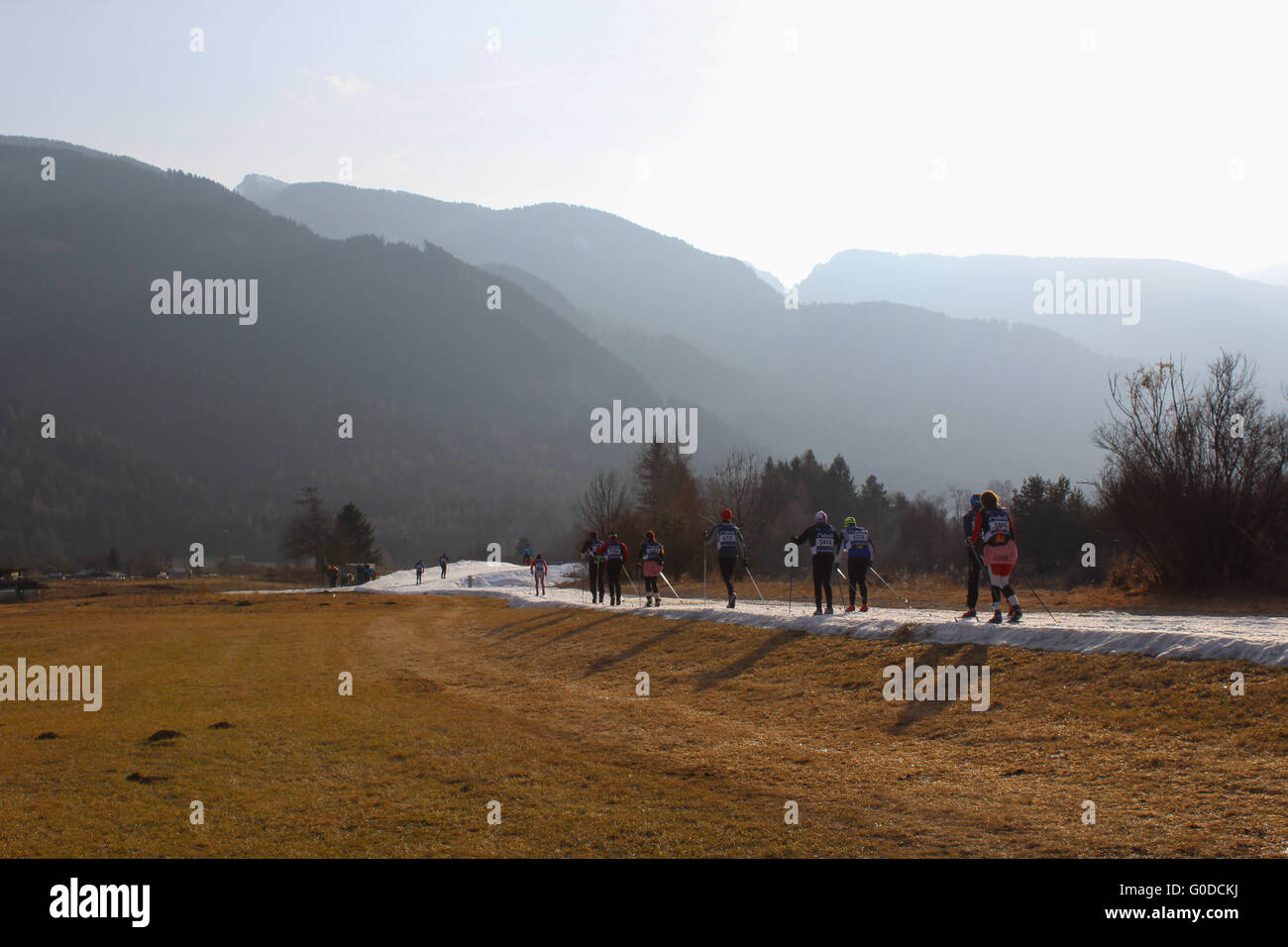 Gli sciatori competere nel 2016 Marcialonga attraversano il corso all'ombra delle Dolomiti Foto Stock