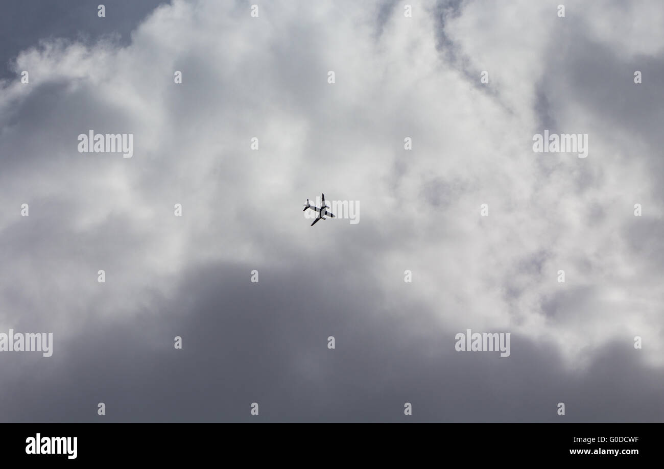 Un velivolo vola al di sotto di nubi in avvicinamento per l'atterraggio all' Aeroporto di Heathrow di Londra, Regno Unito Foto Stock