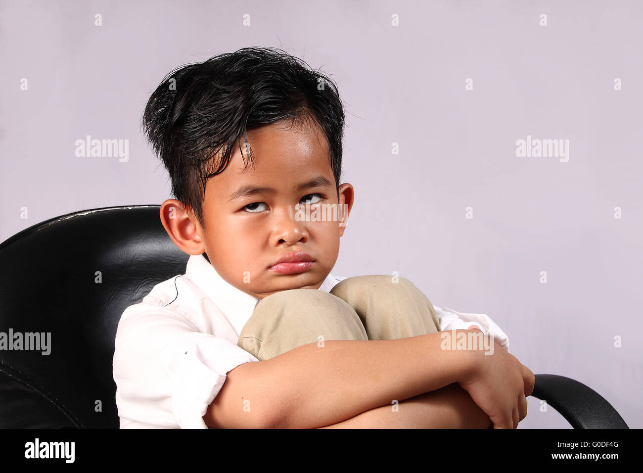 Ritratto di triste ragazzo asiatico mise la faccia sulle ginocchia Foto Stock