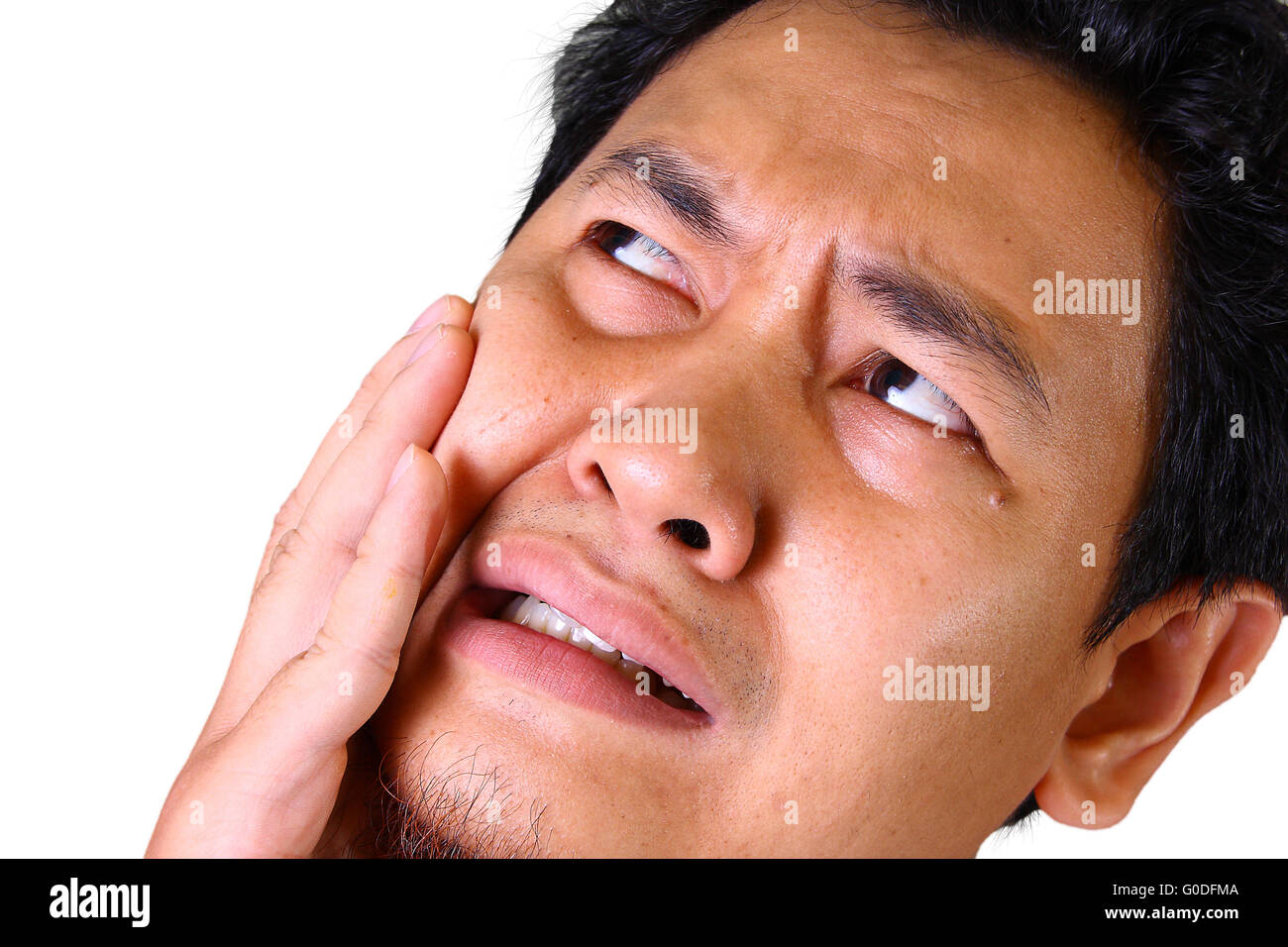 Giovane uomo asiatico nel dolore di mal di denti tenendo la sua guancia Foto Stock