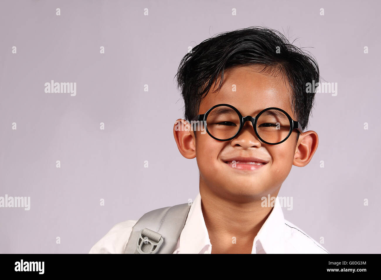 Felice studente asiatico ragazzo indossa occhiali con un grande sorriso sul suo volto Foto Stock