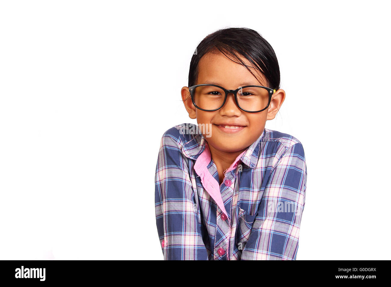 Carino bambina con gli occhiali a sorridere mentre si chiude la sua spalla gesto isolato su bianco Foto Stock