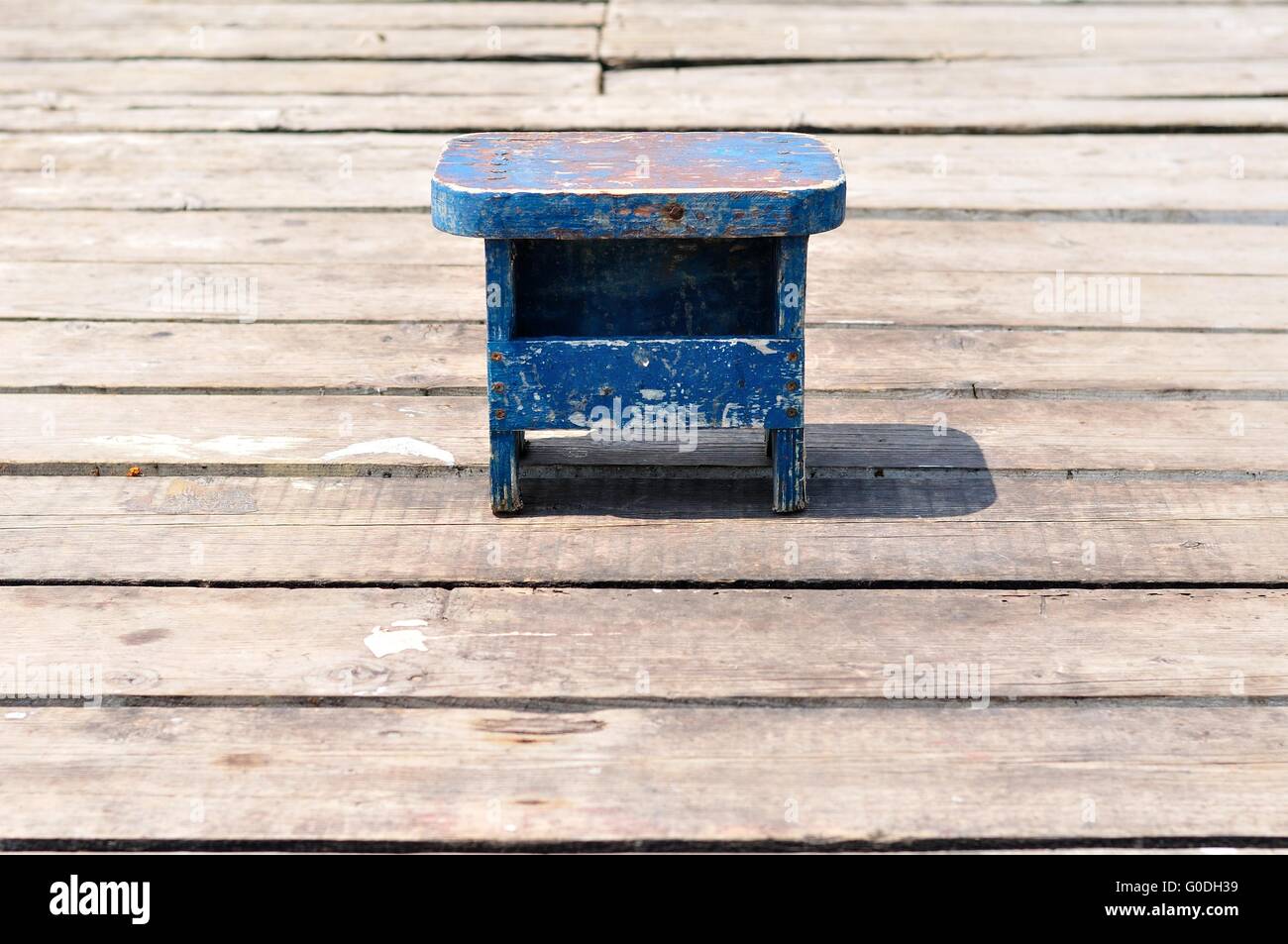 Piccola vecchia blu in legno sedia pesca solo sulla pesca in legno Pier. Croazia, Podgora Foto Stock