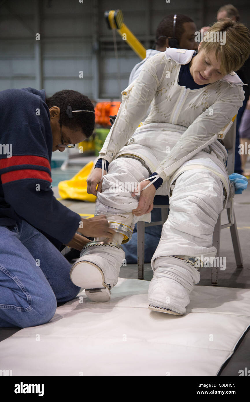L'astronauta della NASA Anne McClain è assistita in adeguamento fino prima di discendere in piscina nel suo Extravehicular Mobility Unit tuta spaziale durante ISS EVA formazione presso la galleggiabilità neutra Laboratorio Johnson Space Center Gennaio 12, 2015 a Houston, Texas. Foto Stock