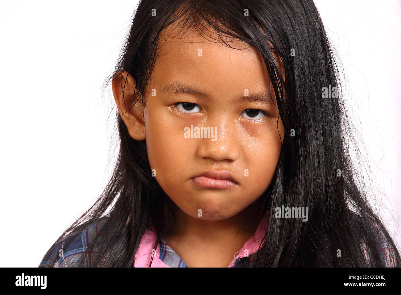 Bambina sembrava arrabbiato isolato su bianco Foto Stock