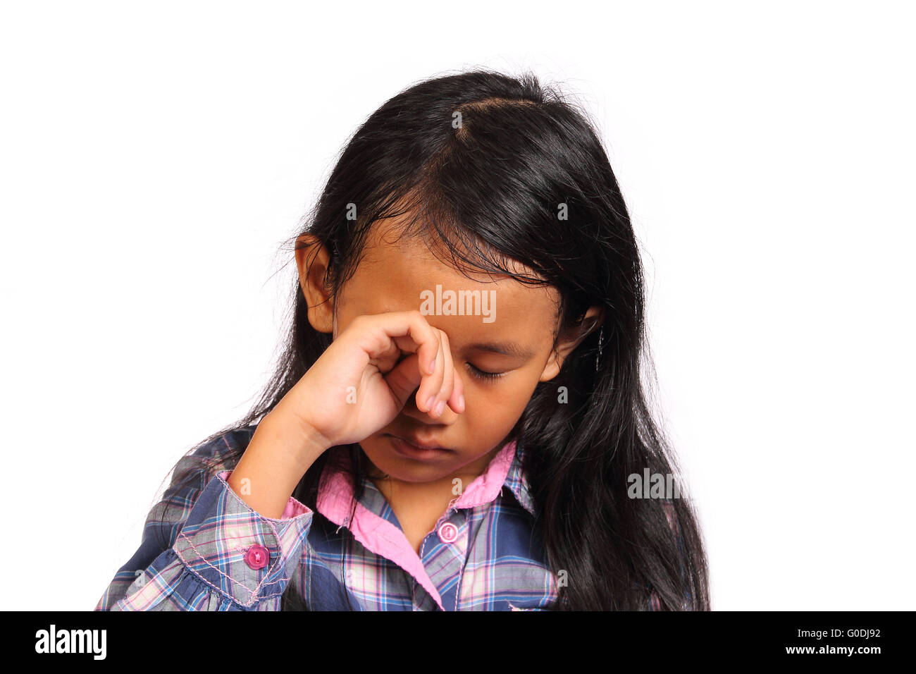 Triste e pianto bambina guardando giù isolato su bianco Foto Stock