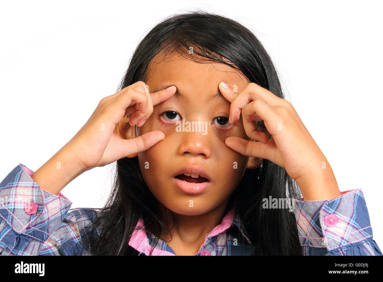 Bambina sembravano stanchi e spingere i suoi occhi aperti con le sue dita isolato su bianco Foto Stock