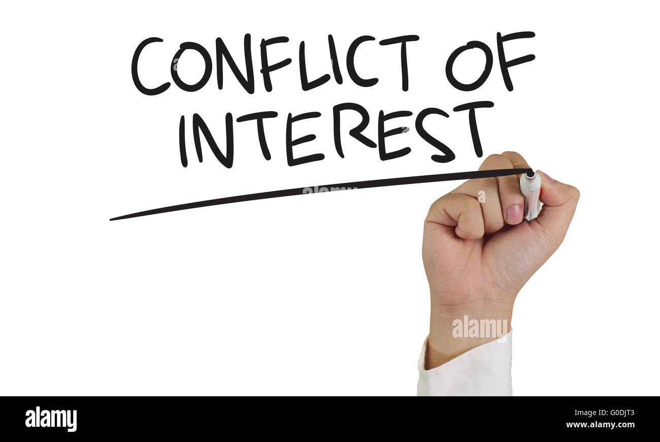 Il concetto di Business immagine di una mano che tiene pennarello e scrivere conflitto di interesse isolato su bianco Foto Stock
