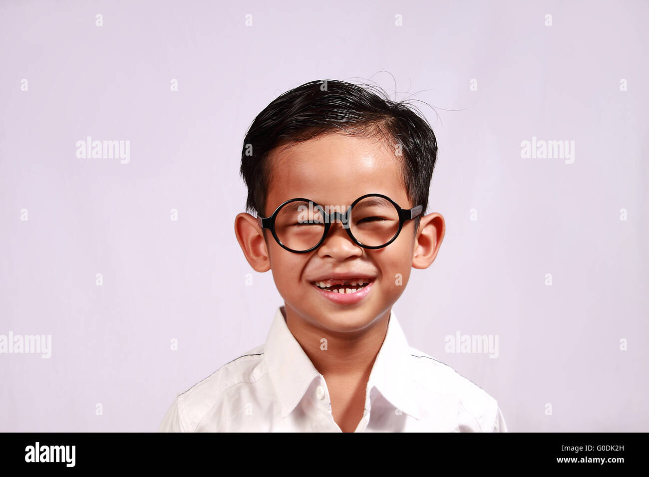 Ritratto di giovane ragazzo asiatico con gli occhiali che mostra il suo sorriso adorabile Foto Stock