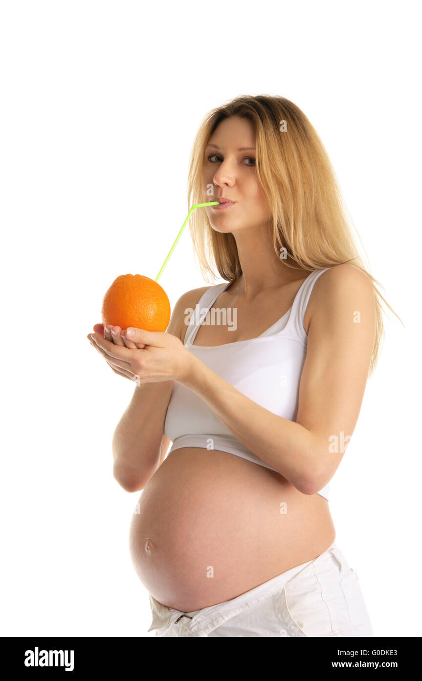 Donna incinta di bere succo di arancia Foto Stock