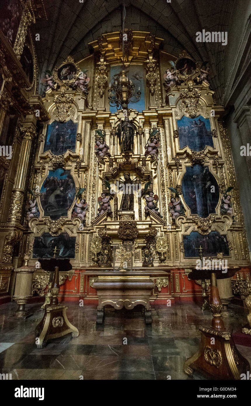 Cappella di San Francesco d'Assisi Retablo città del Messico // CITTÀ DEL MESSICO, MESSICO — la Cappella di San Francesco d'Assisi (Capilla de San Francisco de Asís) presenta un elaborato retablo barocco dorato con due importanti sculture in legno di San Francesco d'Assisi posizionate lungo l'asse verticale centrale. La cappella mostra il santo con stigmate visibili che indossano la tradizionale abitudine francescana, circondato da pannelli narrativi dipinti che raffigurano scene della sua vita, tra cui le stigmate, sermone agli uccelli ed esperienze mistiche. Costruito all'interno della Cattedrale metropolitana dell'assunzione di Foto Stock
