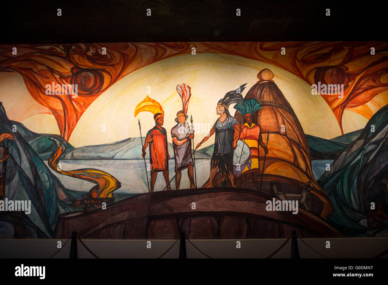 Museo nazionale di antropologia murale dei guerrieri indigeni città del Messico // CITTÀ DEL MESSICO, Messico — Un murale presso il Museo nazionale di antropologia (Museo Nacional de Antropología) raffigura quattro guerrieri indigeni in insegne militari tradizionali. I guerrieri, che indossano copricapi elaborati e trasportano lance e scudi, sono posizionati davanti a una tradizionale struttura ricettiva. Questa opera d'arte illustra aspetti della cultura militare pre-ispanica e dell'abbigliamento cerimoniale. Il Museo Nazionale di Antropologia, fondato nel 1964, ospita una delle collezioni artistiche precolombiane più complete al mondo Foto Stock