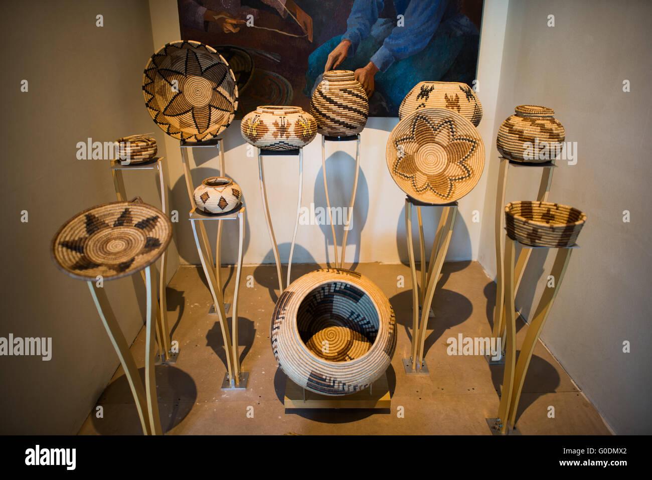 Cesti tessuti Seri Comcaac Museo Nazionale di Antropologia Città del Messico | CITTÀ DEL MESSICO, Messico — Cesti e vasi intrecciati Seri (Comcaac) della costa del Golfo della California nello Sonora sono esposti su supporti individuali nelle gallerie di etnografia del Museo Nazionale di Antropologia, con un dipinto di una tessitrice visibile dietro di loro. I Seri tessono utilizzando stecche di torote (albero elefante, Bursera microphylla) e limberbush (Jatropha cuneata) in motivi geometrici che codificano l'identità del clan, una pratica che è quasi scomparsa a metà del XX secolo ed è stata successivamente ripresa come fonte principale di reddito della comunità Foto Stock