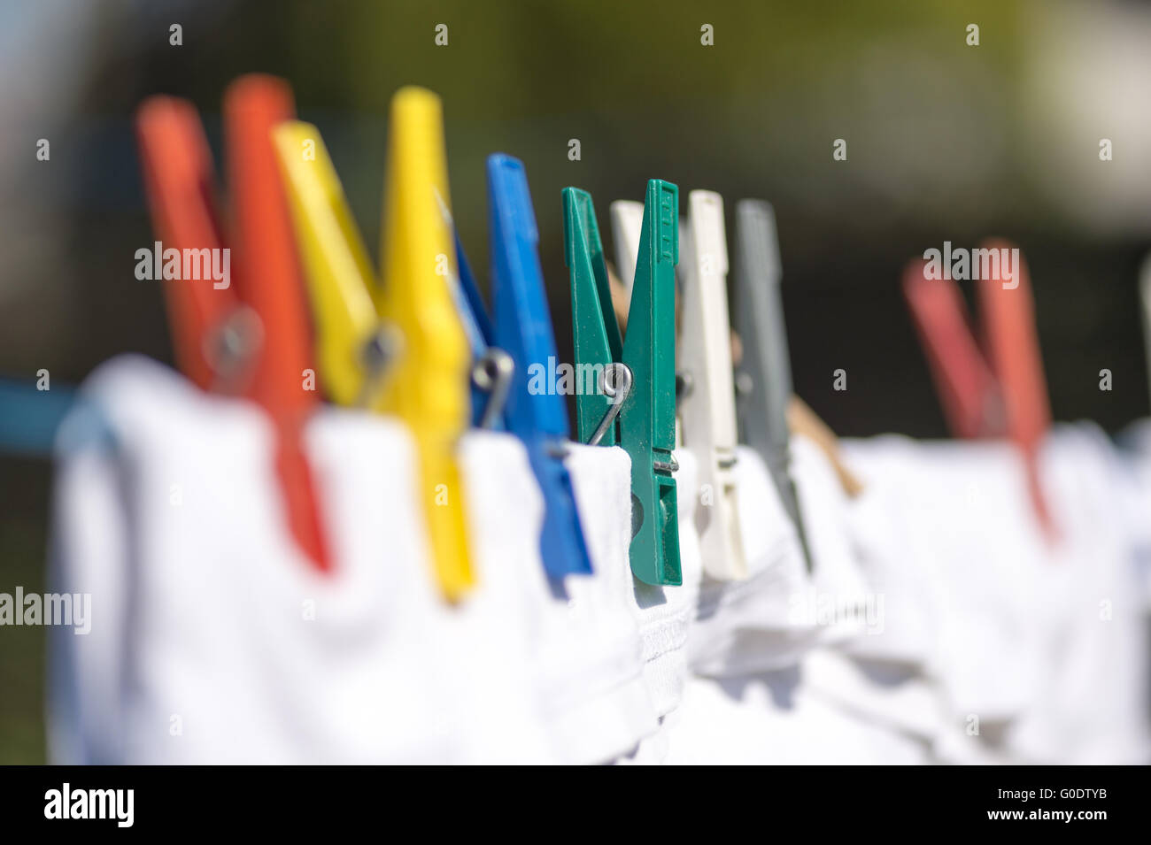 Colorato clothespins holding vestiti di bianco sul Foto Stock