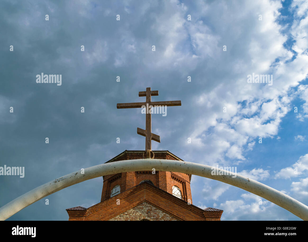 Arco bianco di tubo di ferro con croce scuro su di esso Foto Stock