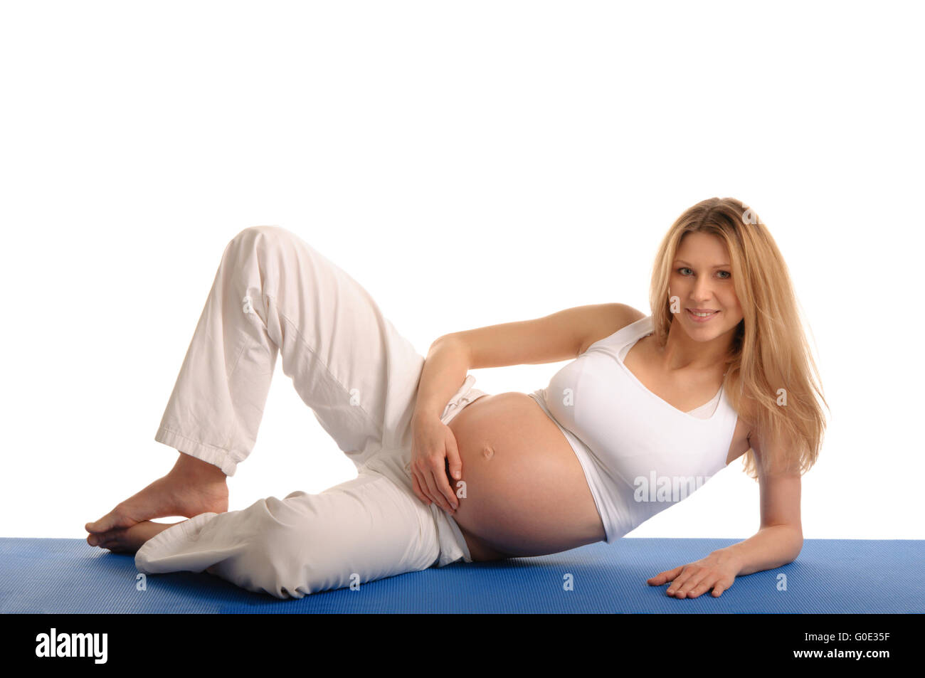 Donna incinta sdraiato e la pratica dello yoga Foto Stock