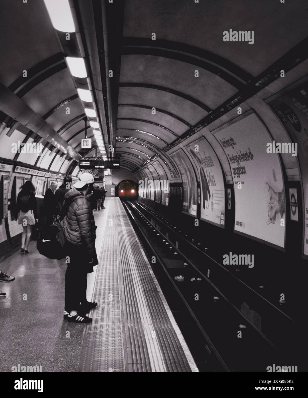 Hyde Park stazione della metropolitana con effetto bianco e nero e un tubo rosso per il treno in avvicinamento da un tunnel. Foto Stock