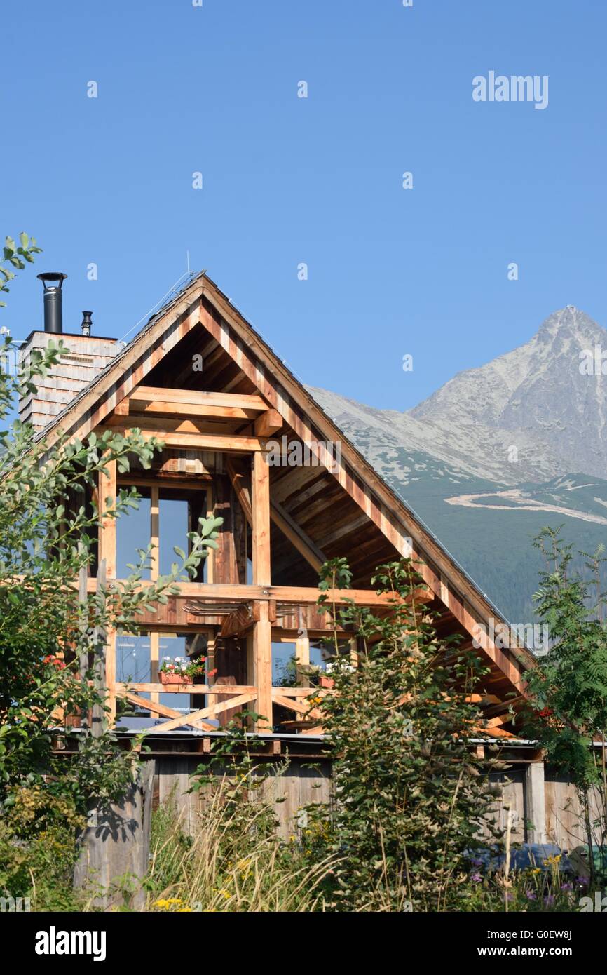 In legno cottage di montagna con le montagne Foto Stock