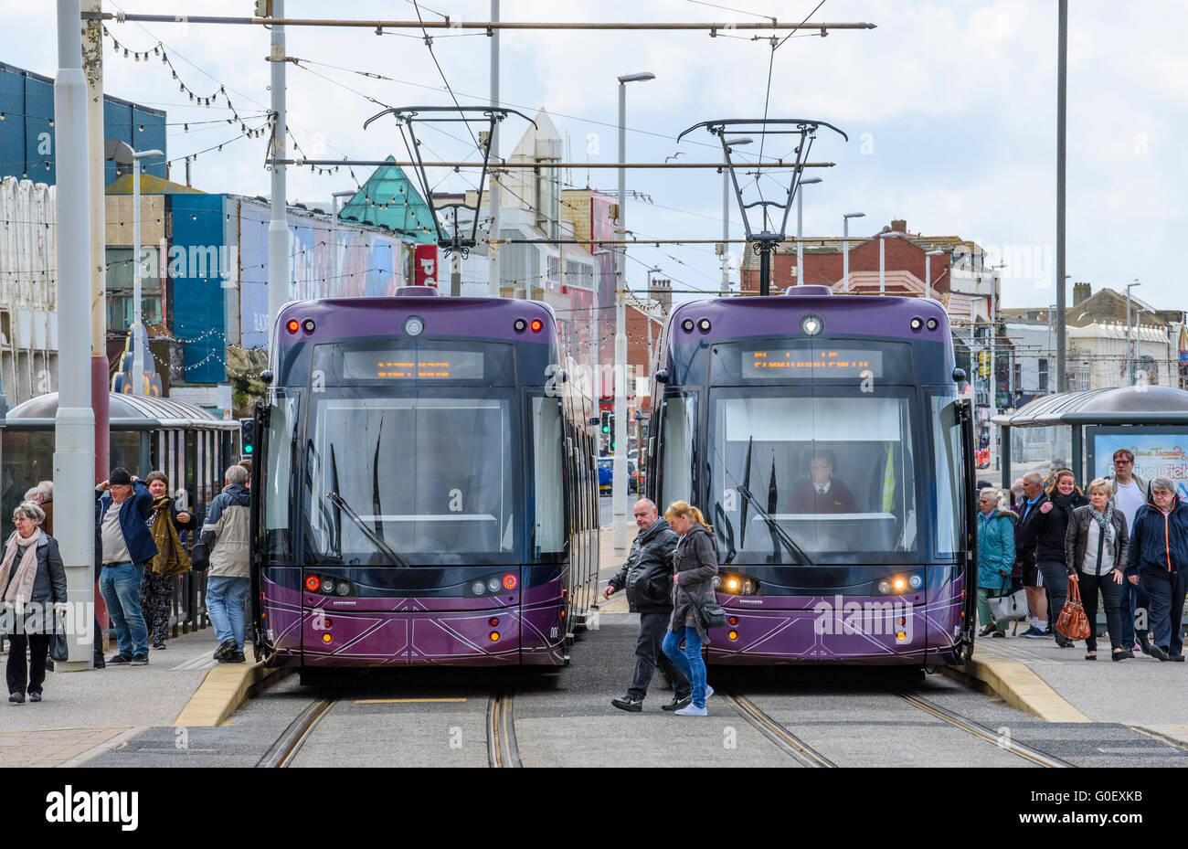 Coppia di Blackpool moderno tram in corrispondenza di una stazione sul lungomare con i passeggeri Foto Stock