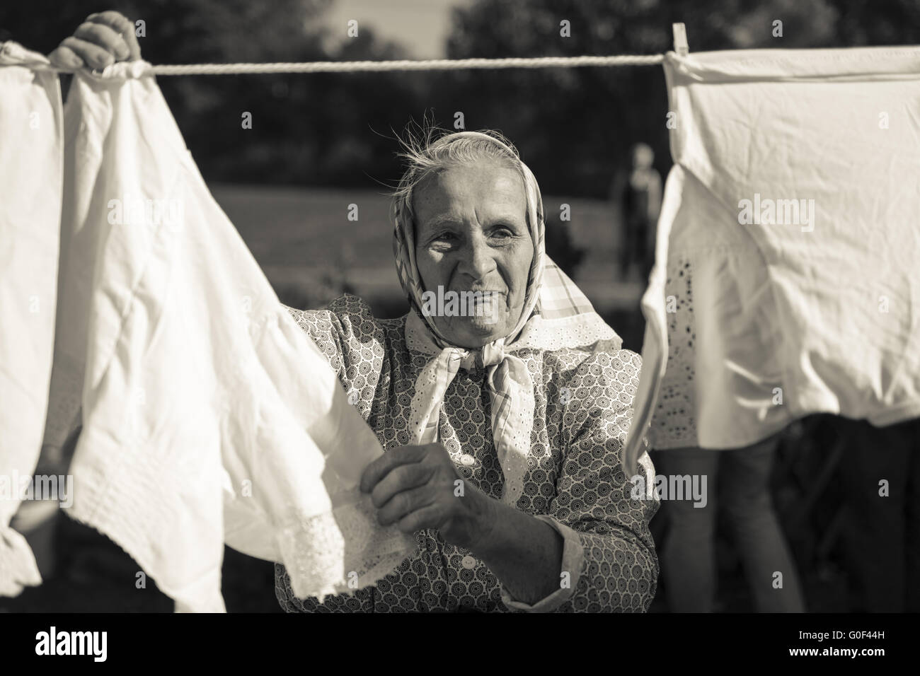 Il vecchio donna alla linea di abbigliamento Foto Stock