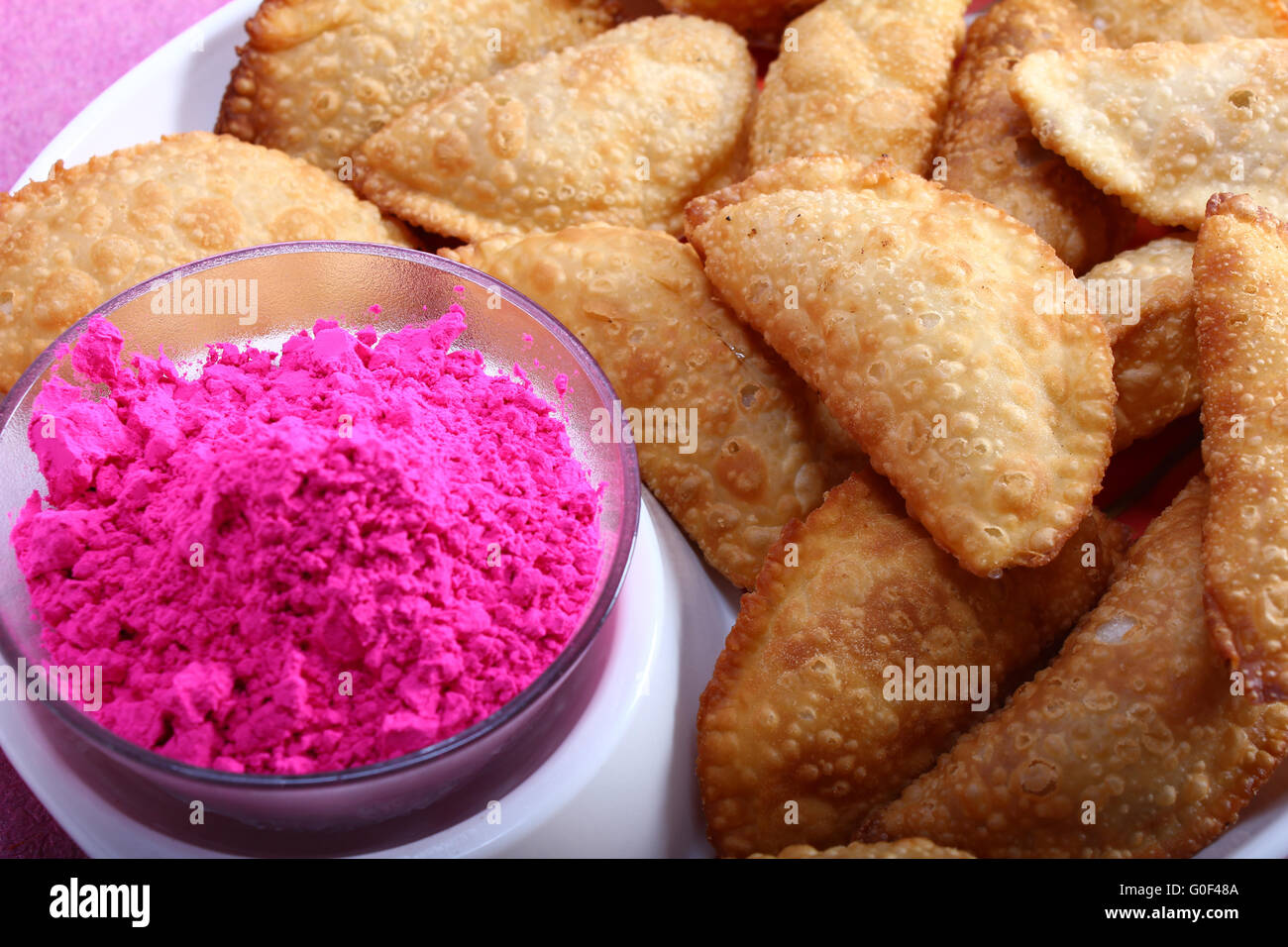 Gujias con colore rosa nel recipiente Foto Stock
