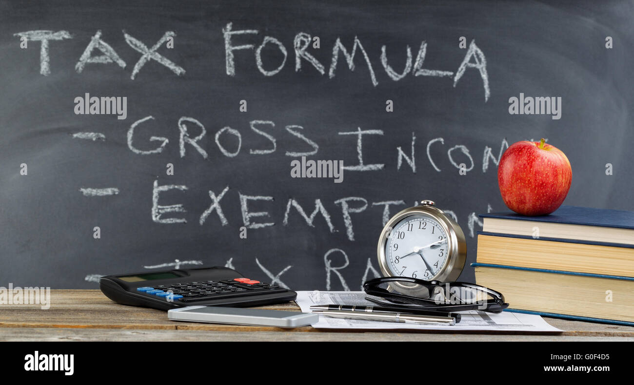 Desktop e lavagna per imparare a fare delle imposte sul reddito in aula Foto Stock