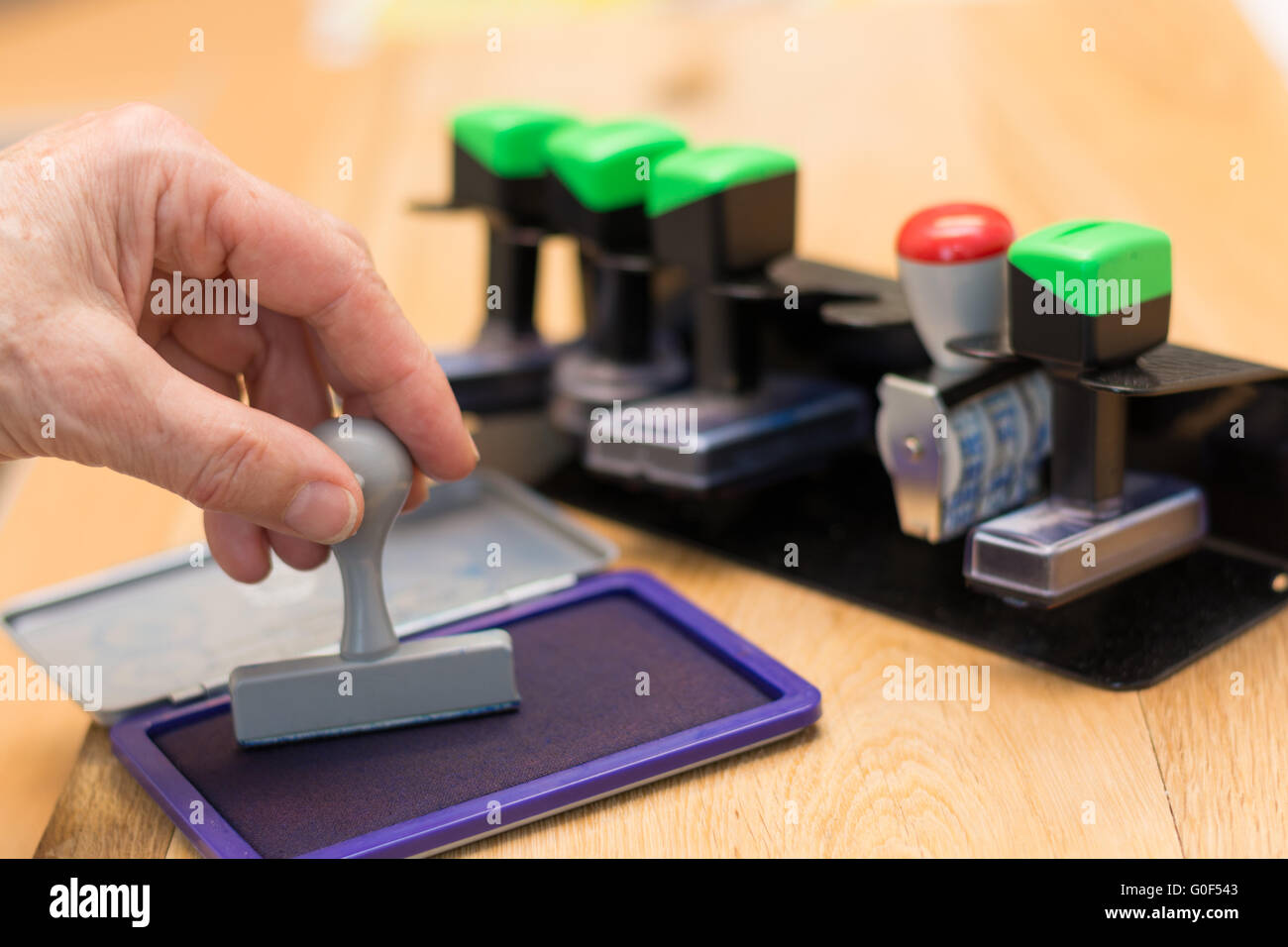 Preme il timbro nel tampone di timbro Foto Stock