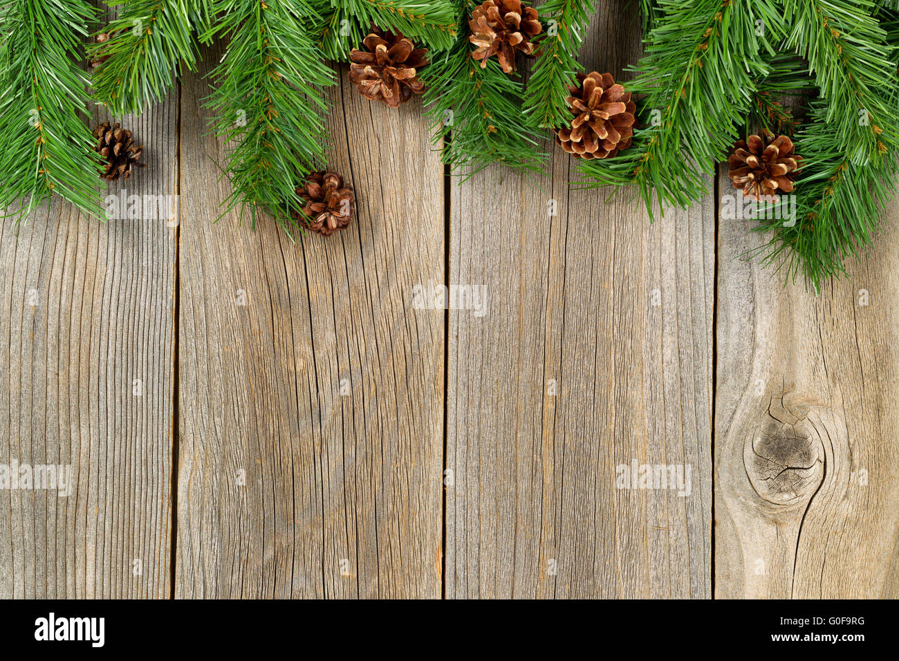 Bordo di Natale con rami e pigne nelle quali su rustiche tavole in legno Foto Stock