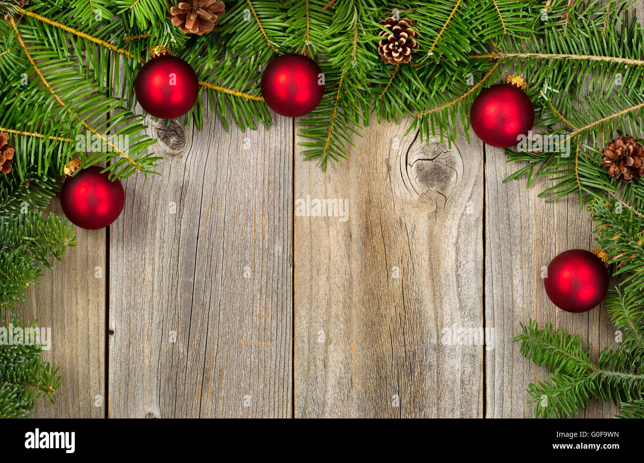 Rami di abete rosso con ornamenti e rocche su rustiche tavole in legno Foto Stock