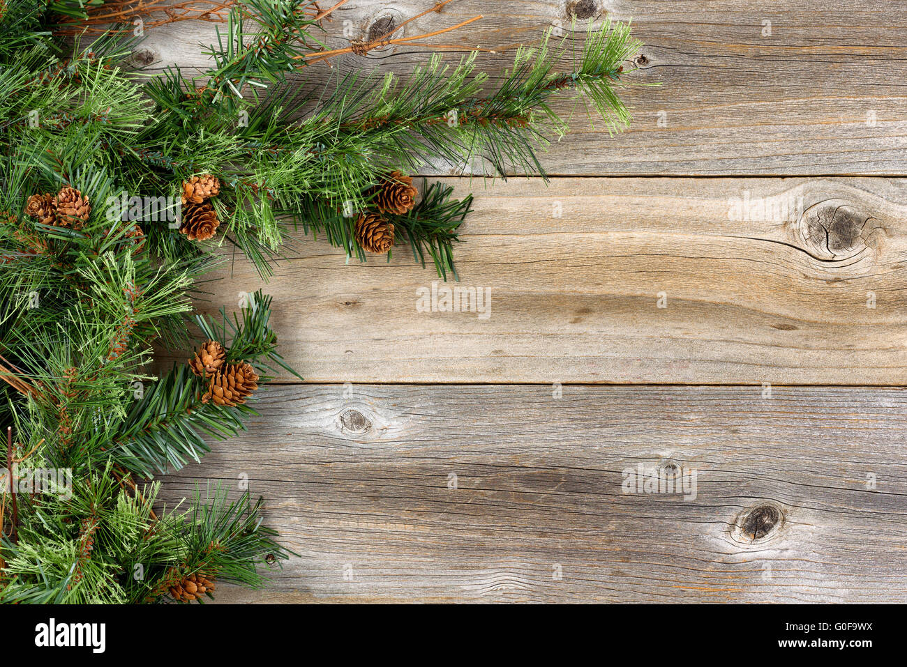 Ruvida rami di abete e coni su rustiche tavole in legno Foto Stock
