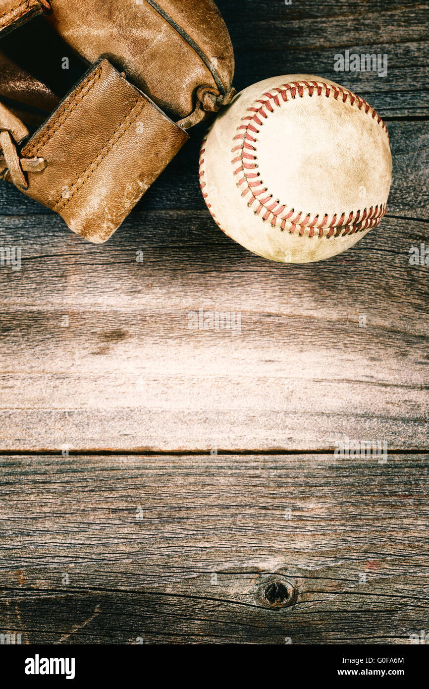 Vecchio di baseball e guanto indossato sul vecchio legno con stile vintage Foto Stock