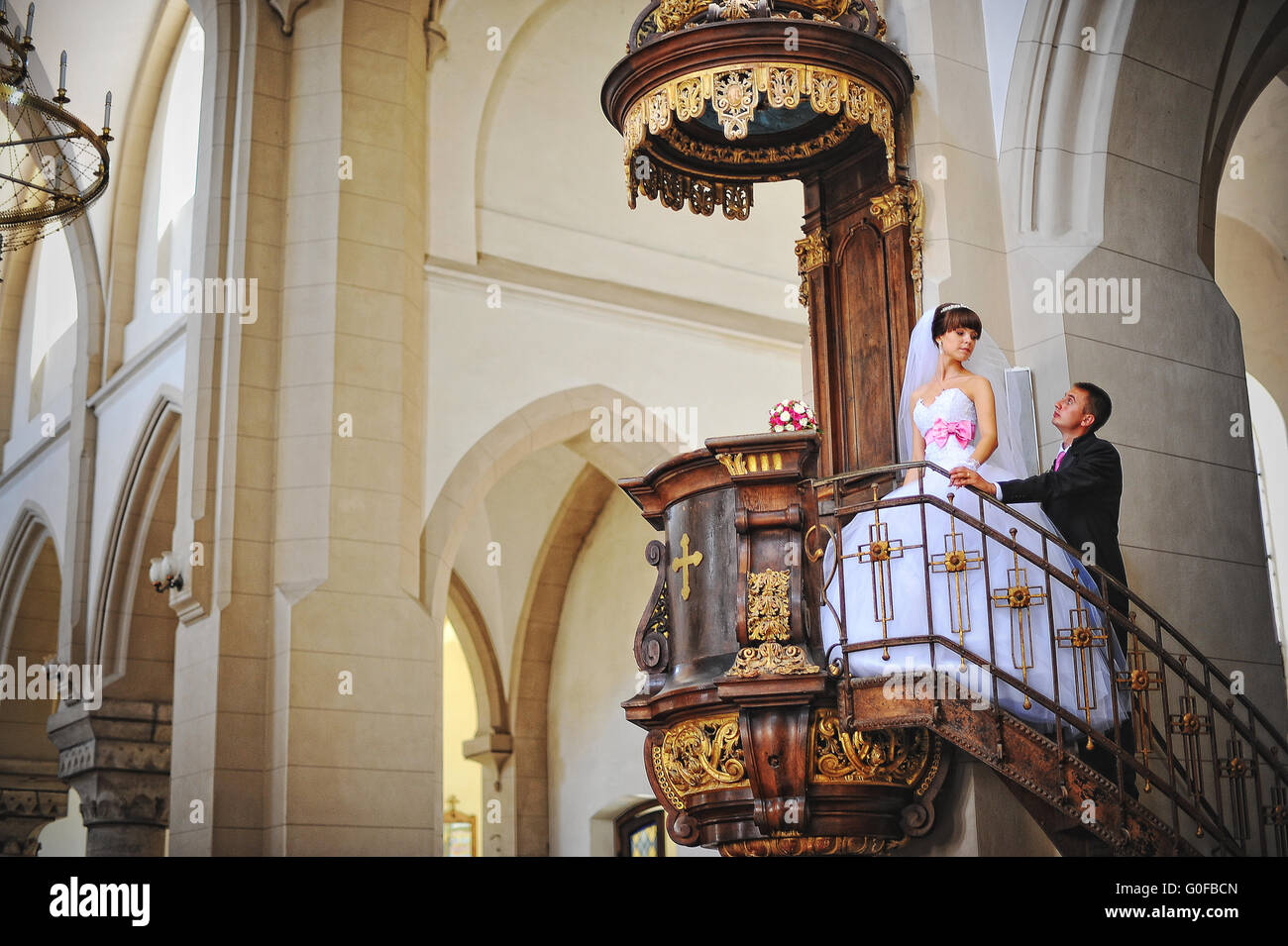 Giovani belle coppie in viaggio di nozze presso la vecchia chiesa cattolica Foto Stock