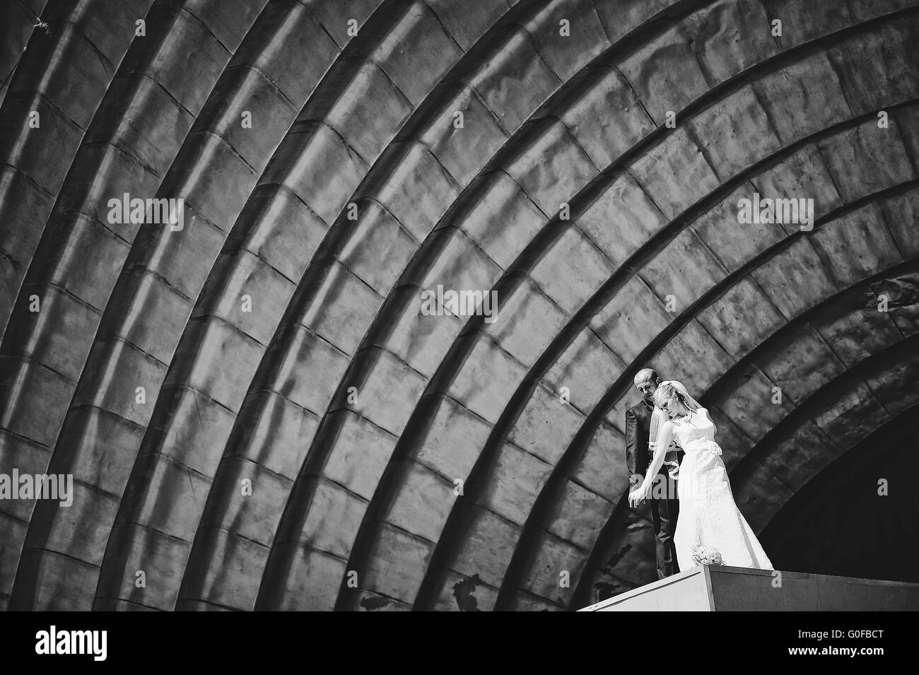 Appena una coppia sposata a camminare in amore sotto opera hall Foto Stock