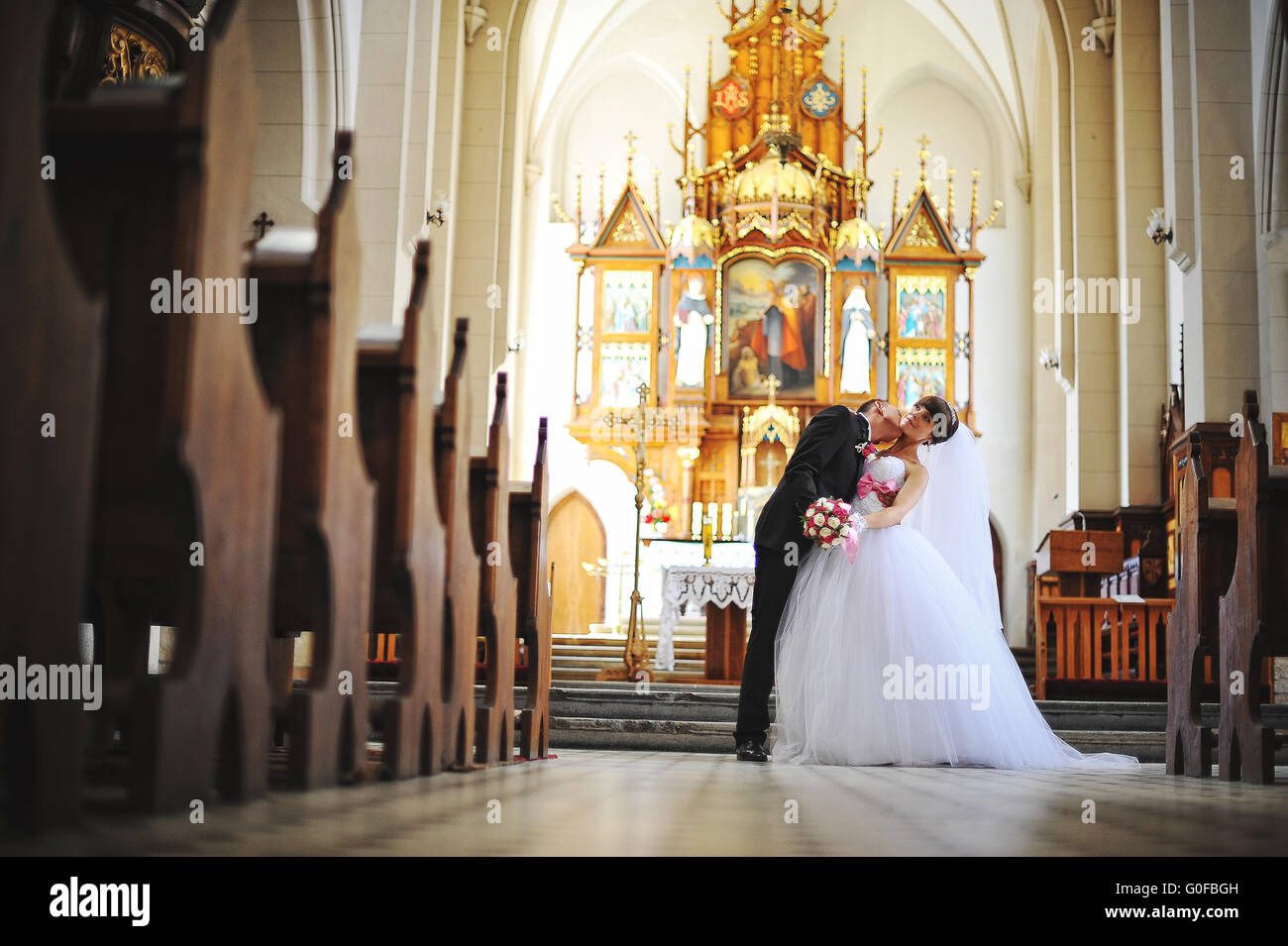 Giovani belle coppie in viaggio di nozze presso la vecchia chiesa cattolica Foto Stock