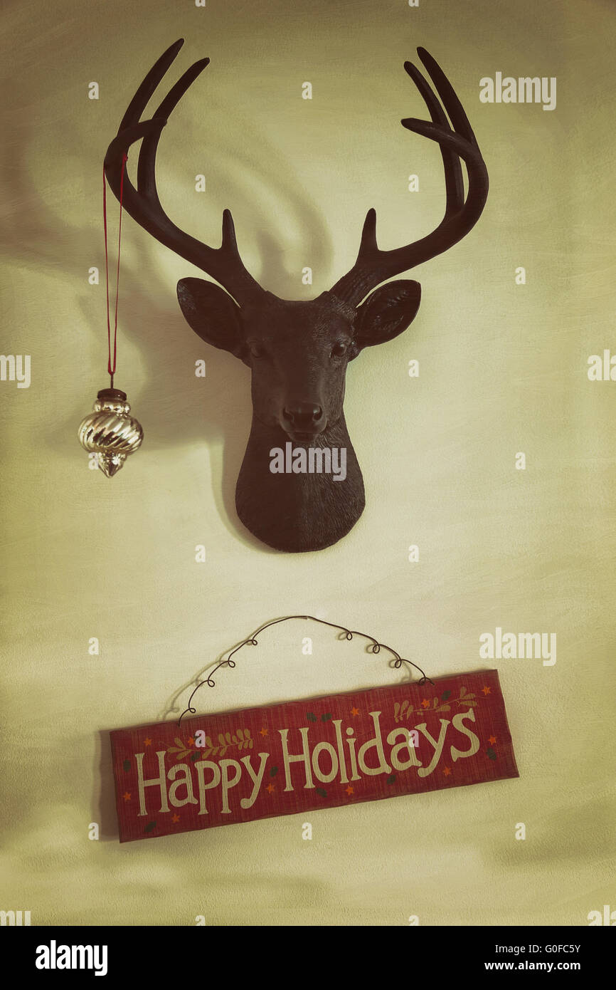 Primo piano della montato di testa di cervo con ornamento di Natale e segno di vacanza Foto Stock