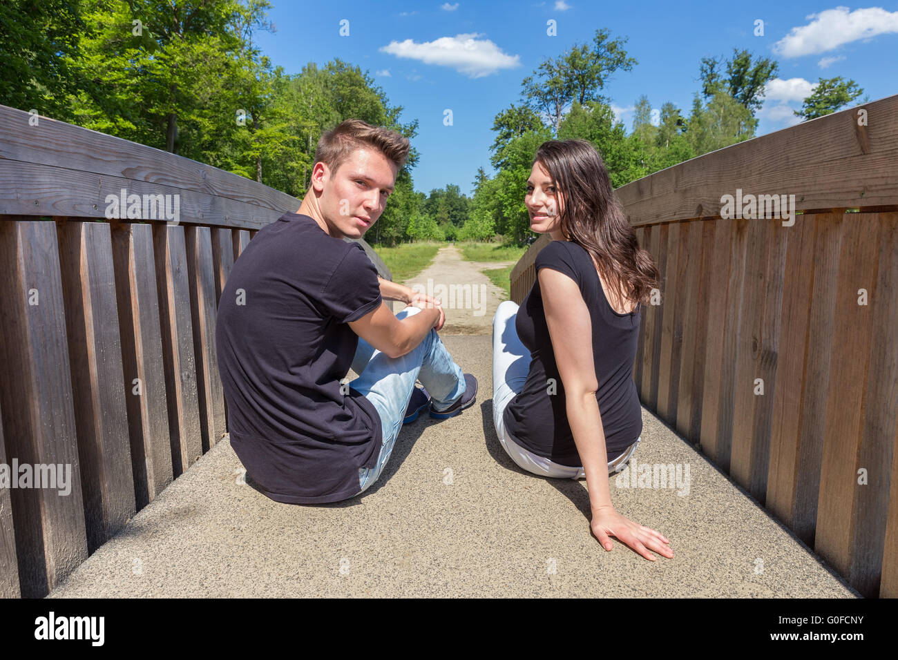 Attraente giovane coppia olandese seduto sul ponte di legno Foto Stock