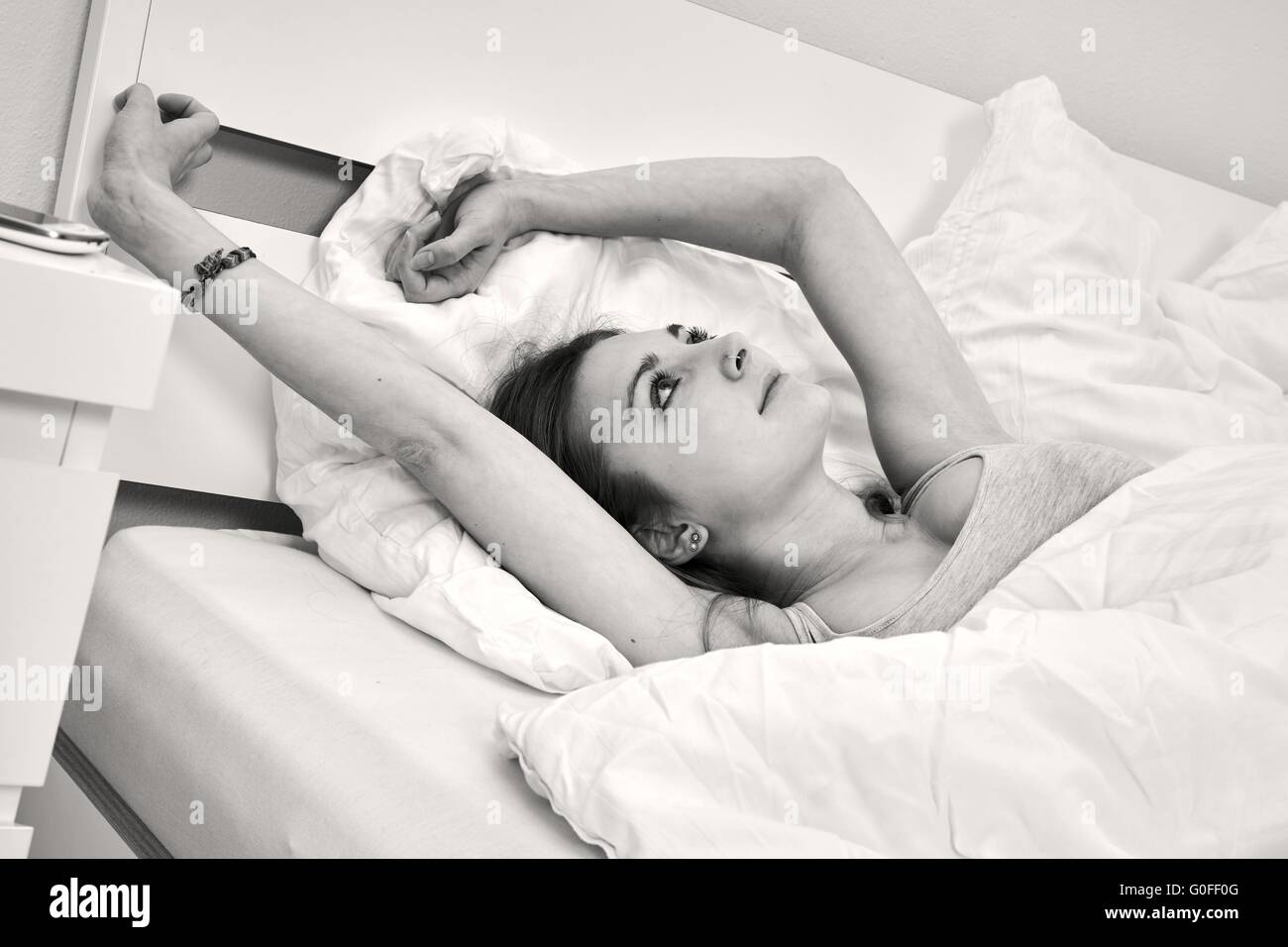Giovane donna giaceva nel suo letto Foto Stock