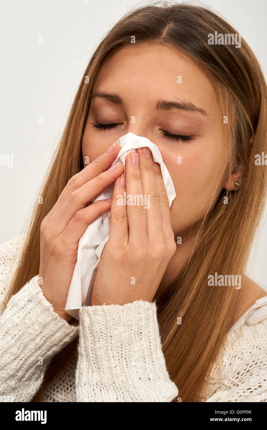 Giovane donna soffia il naso Foto Stock