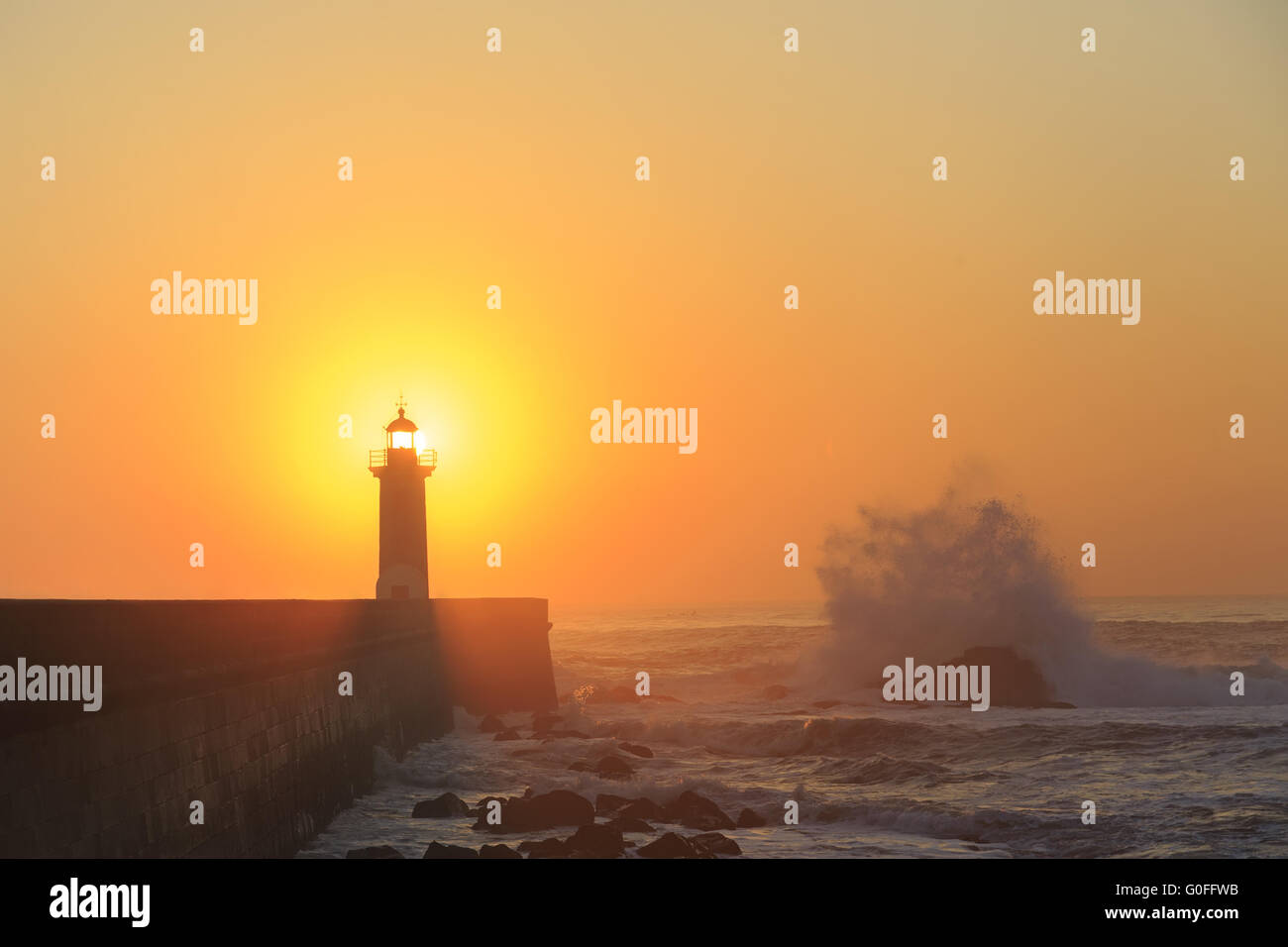 Faro Felgueirasin Porto con schizzi d'onda al tramonto Foto Stock