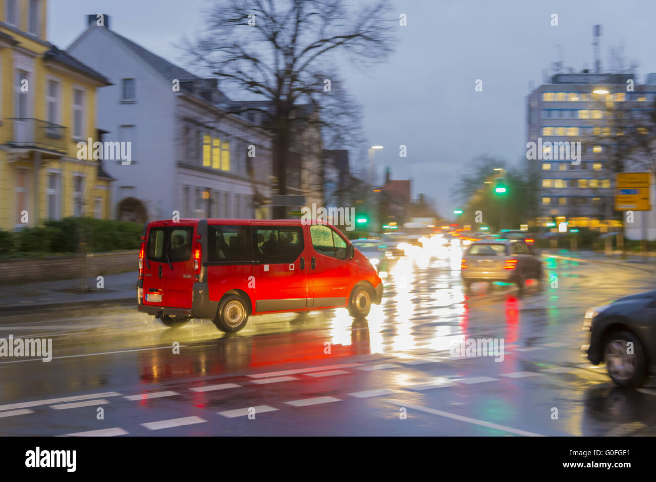 Un auto rossa alla luce dei veicoli che sopraggiungono in senso contrario Foto Stock