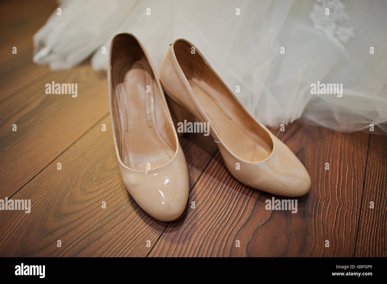 Color crema scarpe matrimonio sul pavimento in legno Foto Stock