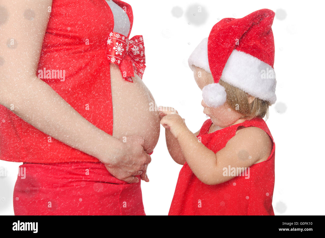 Il bambino e la donna incinta ventre a Natale, i fiocchi di neve Foto Stock