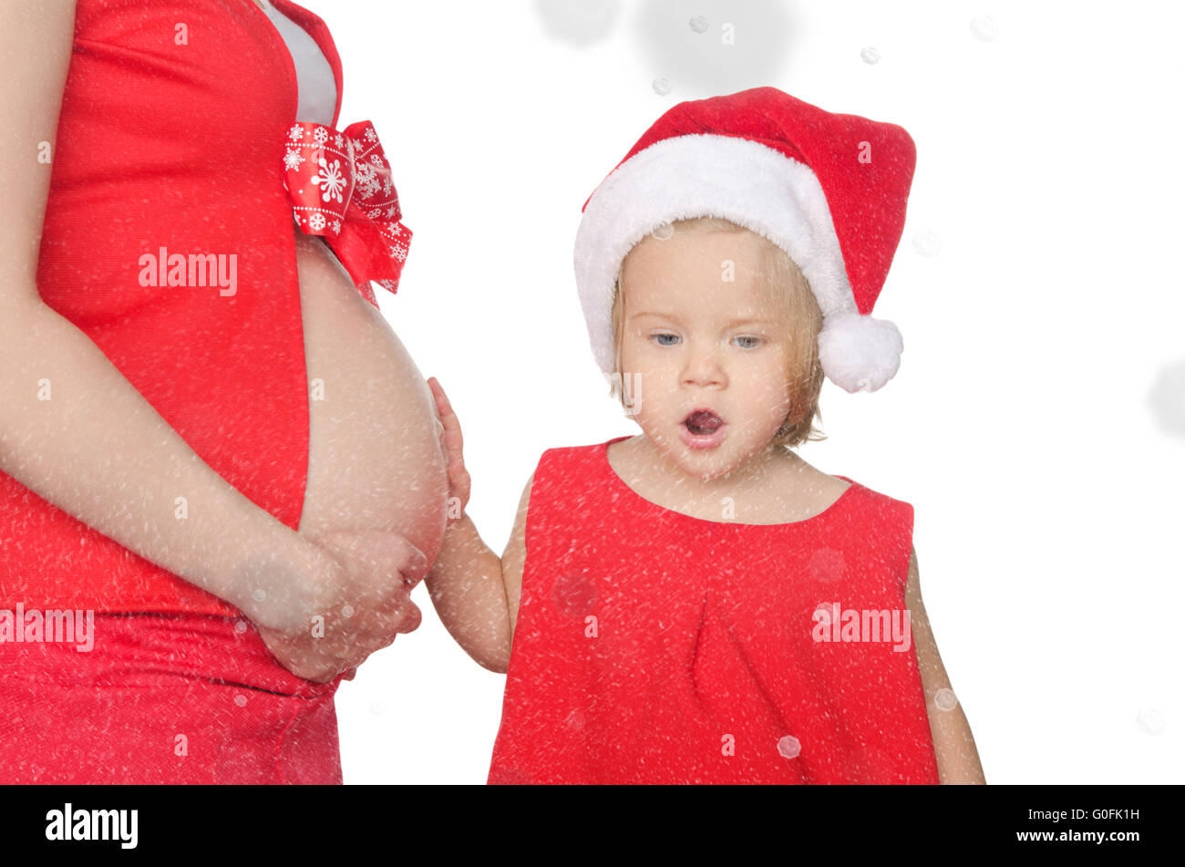 Sorpreso il bambino e la donna incinta nel Natale, i fiocchi di neve Foto Stock