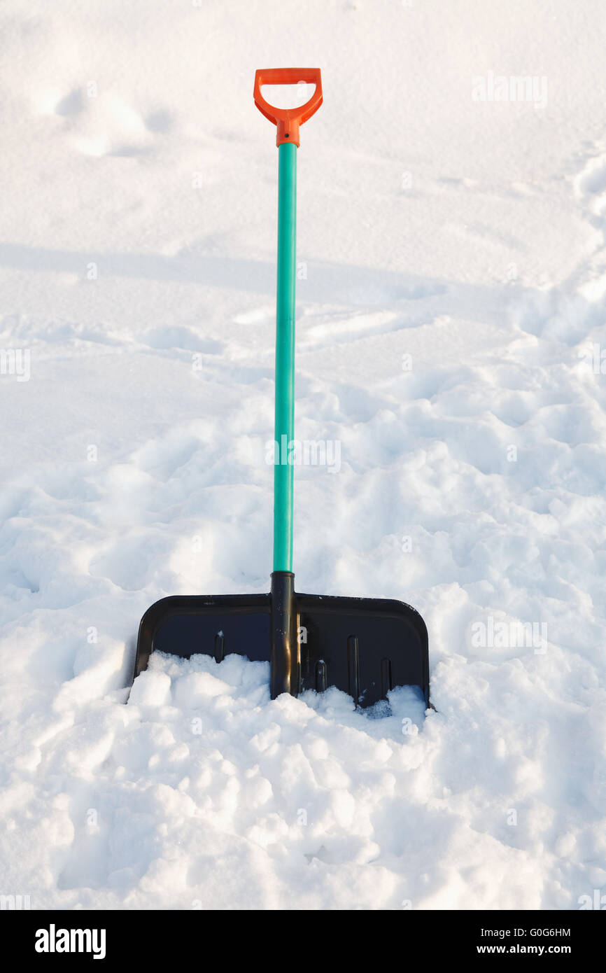 Pala per neve bastoncini di pulizia in un cumulo di neve Foto Stock