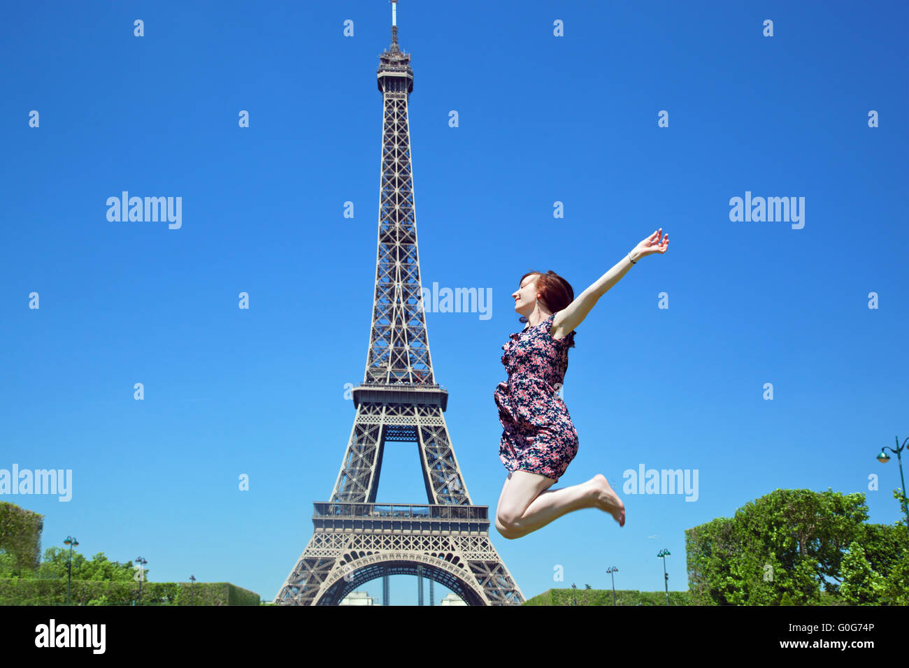 Giovani attraenti jumping contro la Torre Eiffel, Parigi, Francia Foto Stock