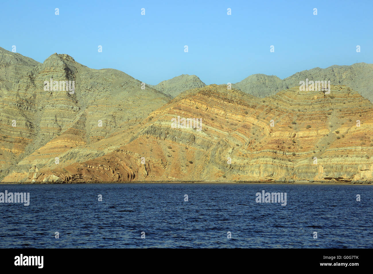 Il mare blu e scogli colorati nel fiordo Khor Ash Sham in Oman Foto Stock